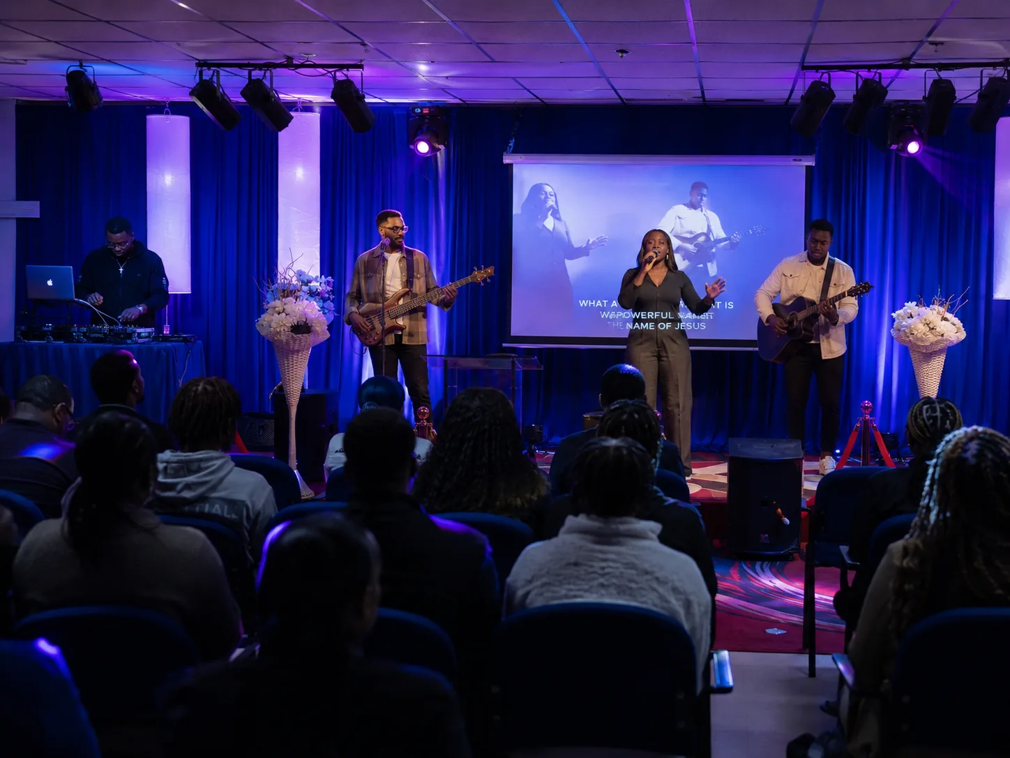 Worship band leading praise on stage under dynamic stage lighting
